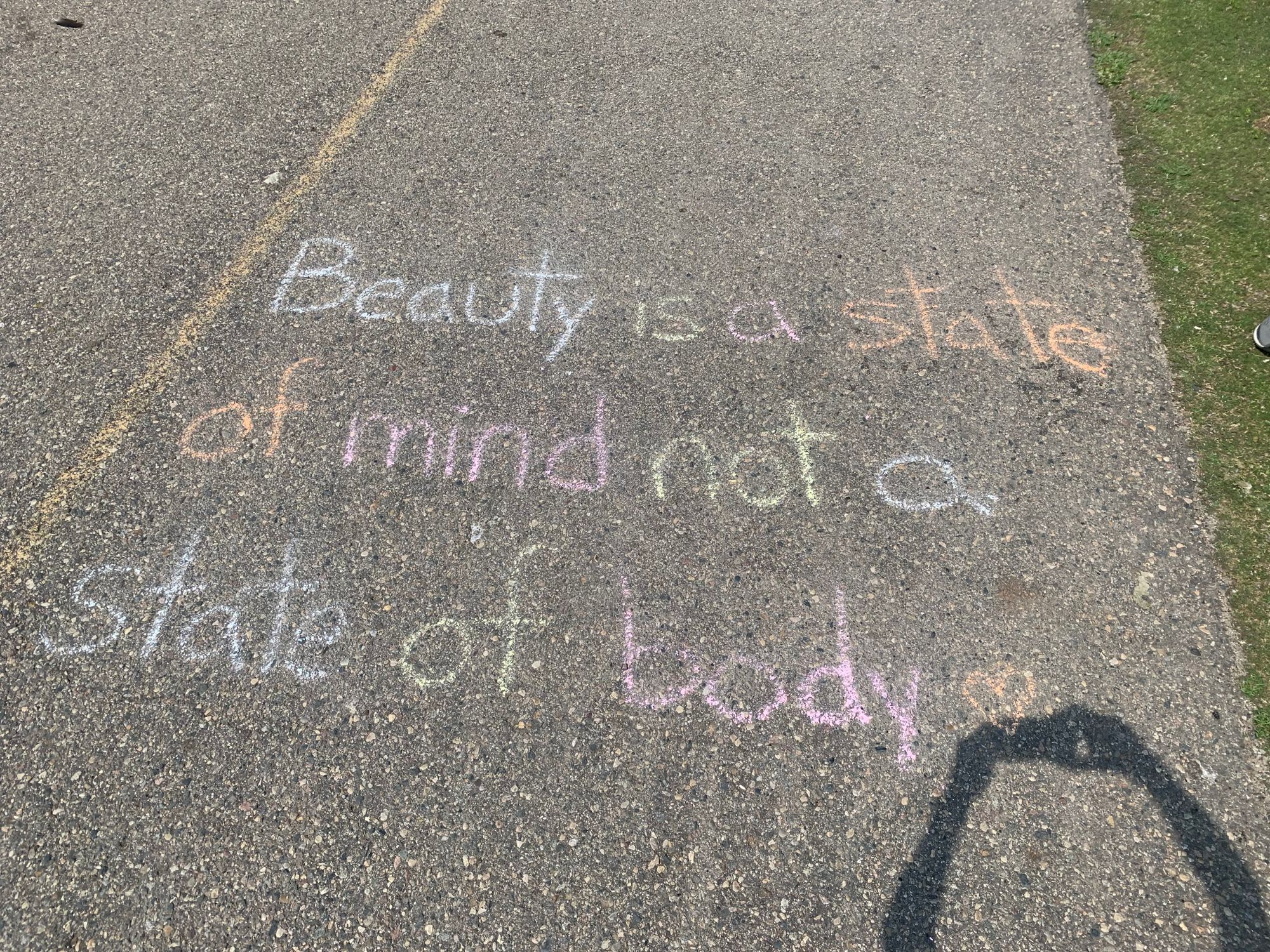 "Beauty is a state of mind not a state of body,” written in chalk on the sidewalk.